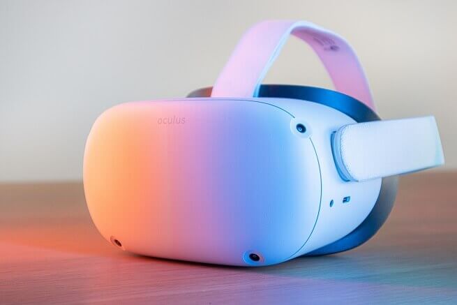 Meta Oculus Quest 2 VR 白色頭戴顯示器，上方映照出反射的彩色光線，散發出魅惑般的色澤